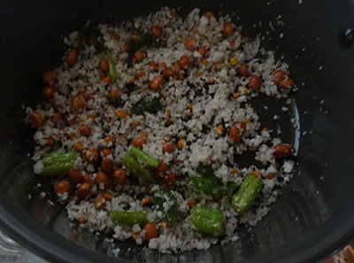 mixing salt, suagr and beaten rice for avalakki upkari or poha snacks