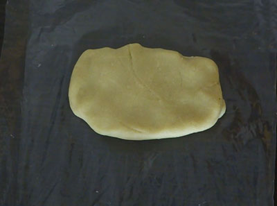 badam burfi or badam katli dough on greased plastic sheet