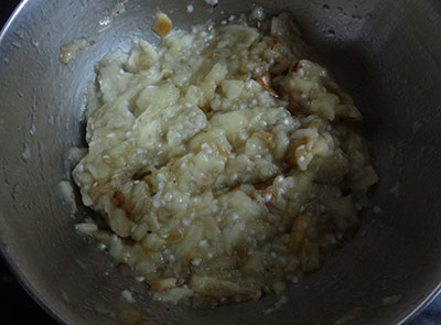 mashing charred brinjal for sutta badanekayi mosaru bajji