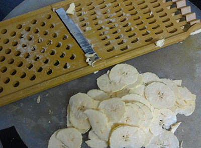 slicing raw banana for banana chips or balekai chips
