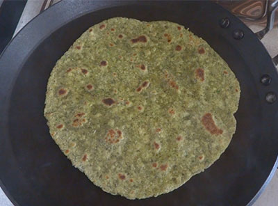 flipping and cooking hesarukalu chapathi or moong paratha