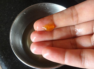 checking soft ball consistency of jaggery syrup for athrasa or kajjaya