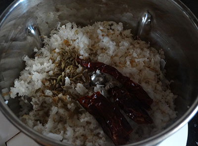 grind coconut and red chili for padavalakai palya or snake gourd stir fry
