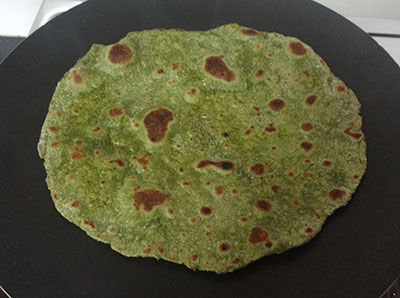 flipping and cooking palak paratha or parota