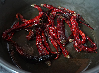 frying red chilis for mysore rasam powder or iyengar puliyogare powder