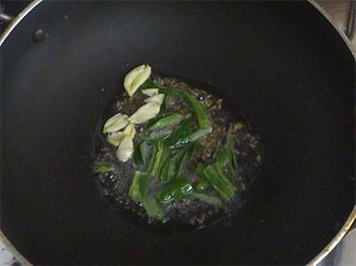 garlic, green chili and curry leaves for tomato bellulli gojju or tomato garlic gojju