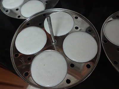 pour the batter in idli moulds for soft idli using dosa rice or ration akki