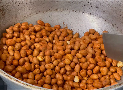 frying spice coated peanuts for masale shenga or kadalebeeja hurigaalu