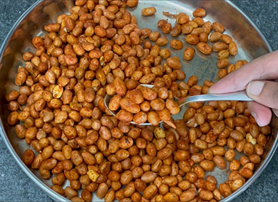 frying spice coated peanuts for masale shenga or kadalebeeja hurigaalu