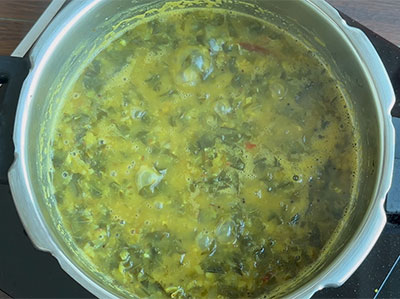 boiling nugge soppu or drumstick leaves or moringa dal